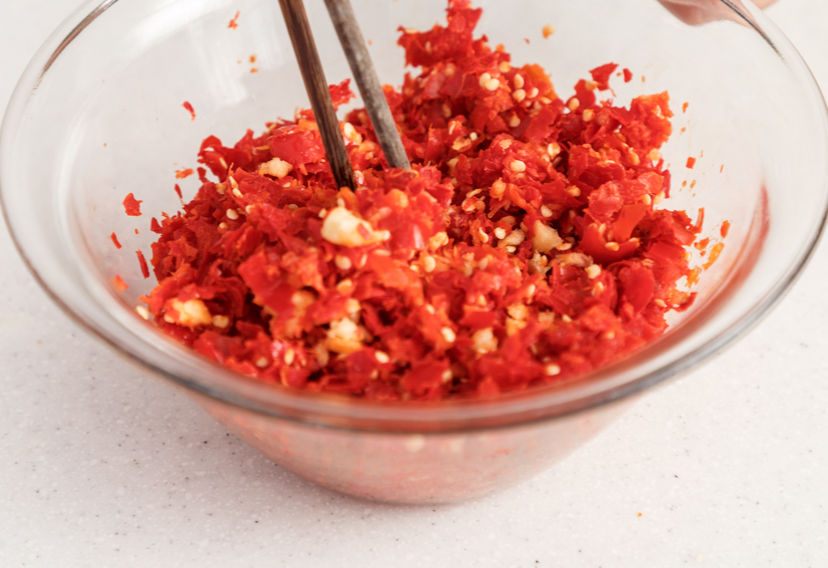 Combine chili peppers, garlic, white wine, and salt for flavorful sauce, letting it marinate to enhance taste.