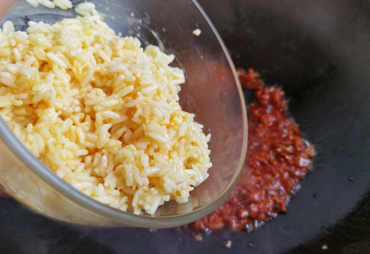 Stir-fry mixed leftover rice in a pan until coated and colored. Transfer to plate.