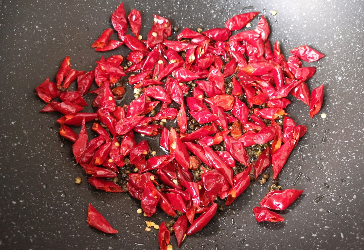 Heat rapeseed oil with red chilies, Sichuan peppercorns, and star anise until fragrant.