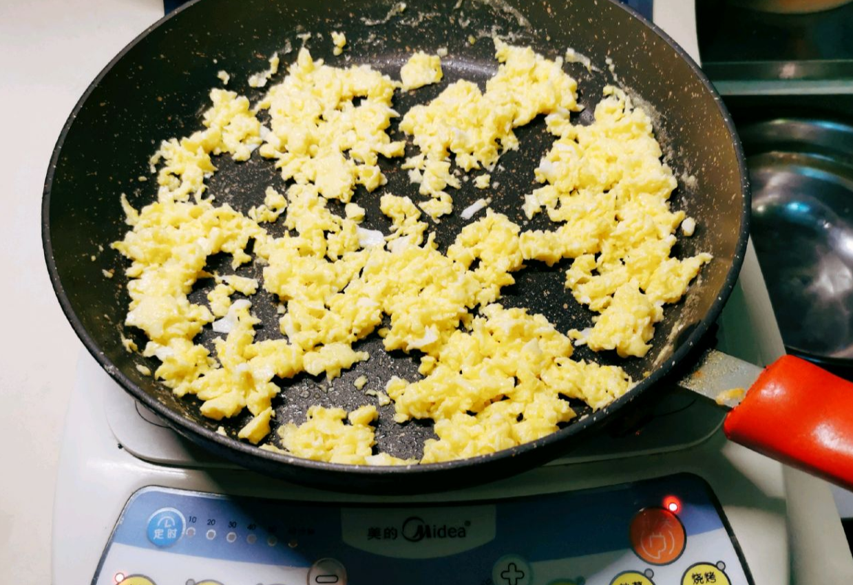 Heat oil; add beaten eggs. Scramble on induction cooker until cooked and broken into pieces.