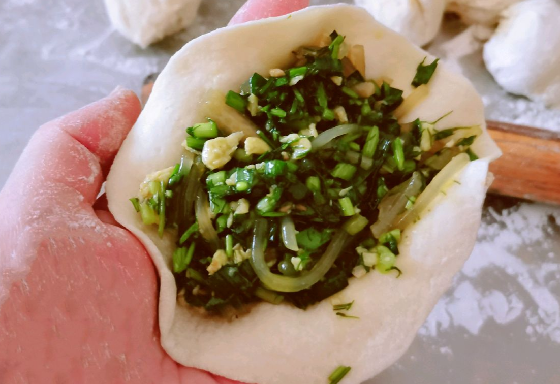 Shape a portion of dough into a round wrapper and wrap around filling.