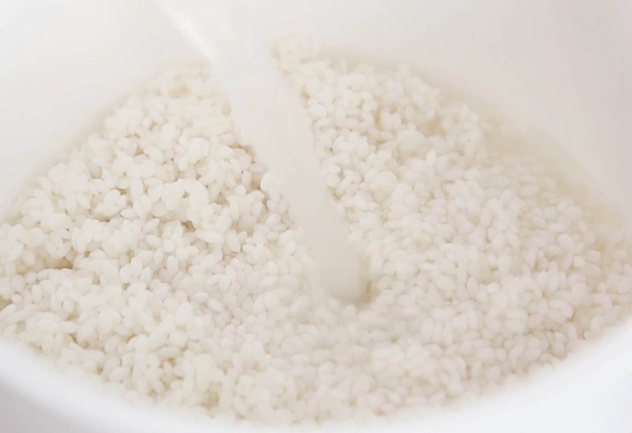 Soak rice, replace water with hot water, add vinegar for whiter rice.