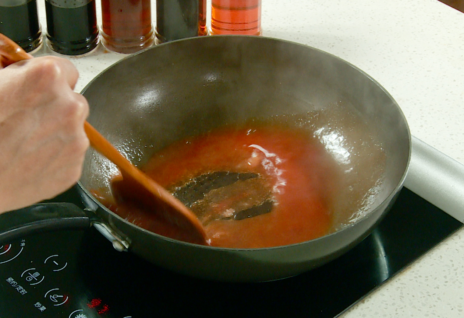 Make sweet and sour sauce by combining vinegar, ketchup, and sugar in a wok with oil.