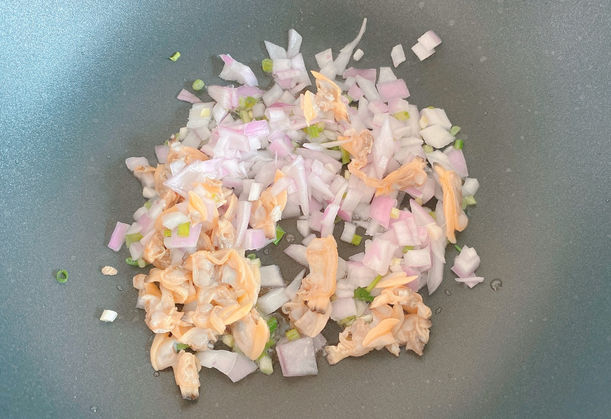 Stir-fry scallions, onions, and razor clam meat in high heat with salt for 2 minutes.