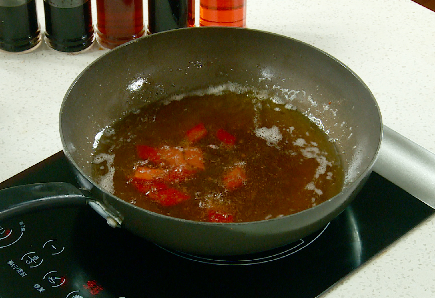 Fry red bell pepper pieces in oil for 5 seconds, then drain.