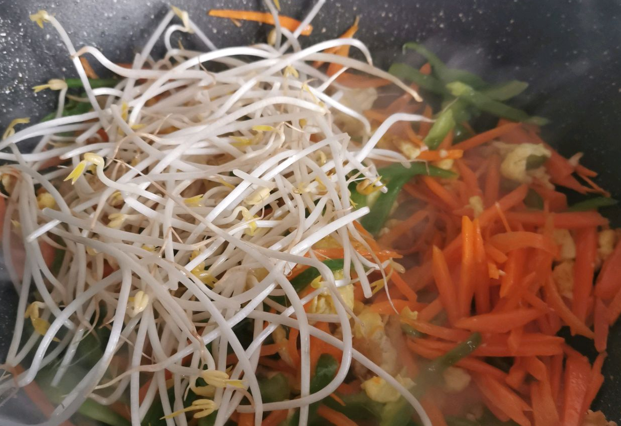 Stir-fry carrots, bell peppers, and bean sprouts until softened.