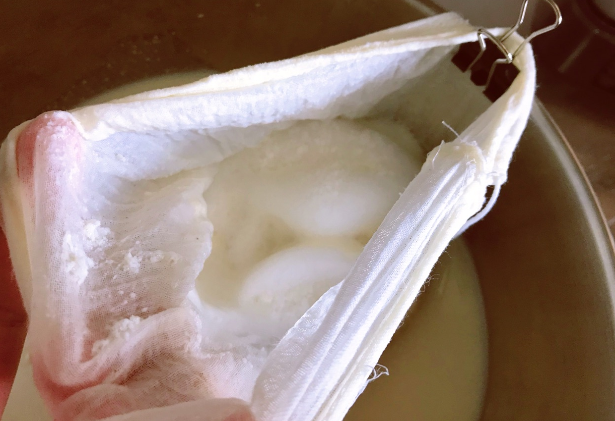 Strain soy milk through cheesecloth to remove foam.