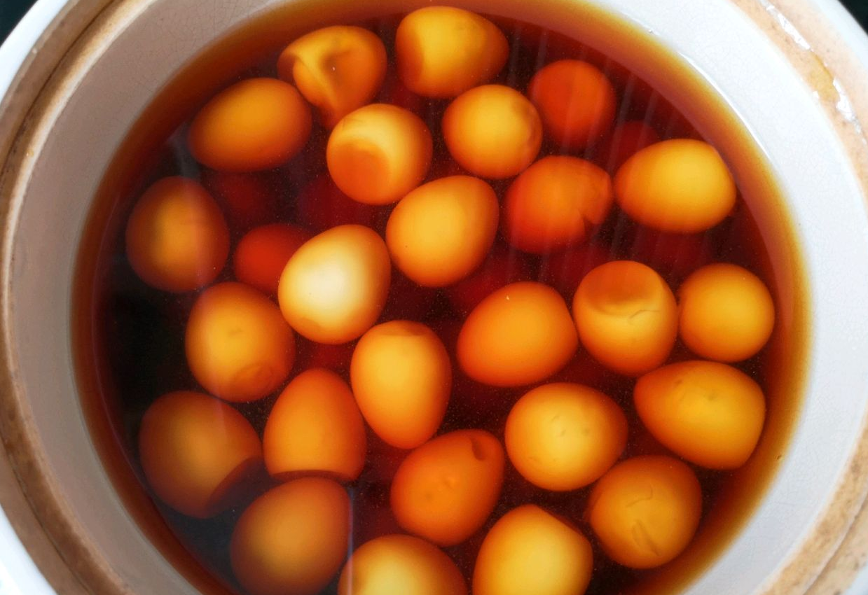 Recipe for simmering quail eggs in soy sauce broth in a clay pot.