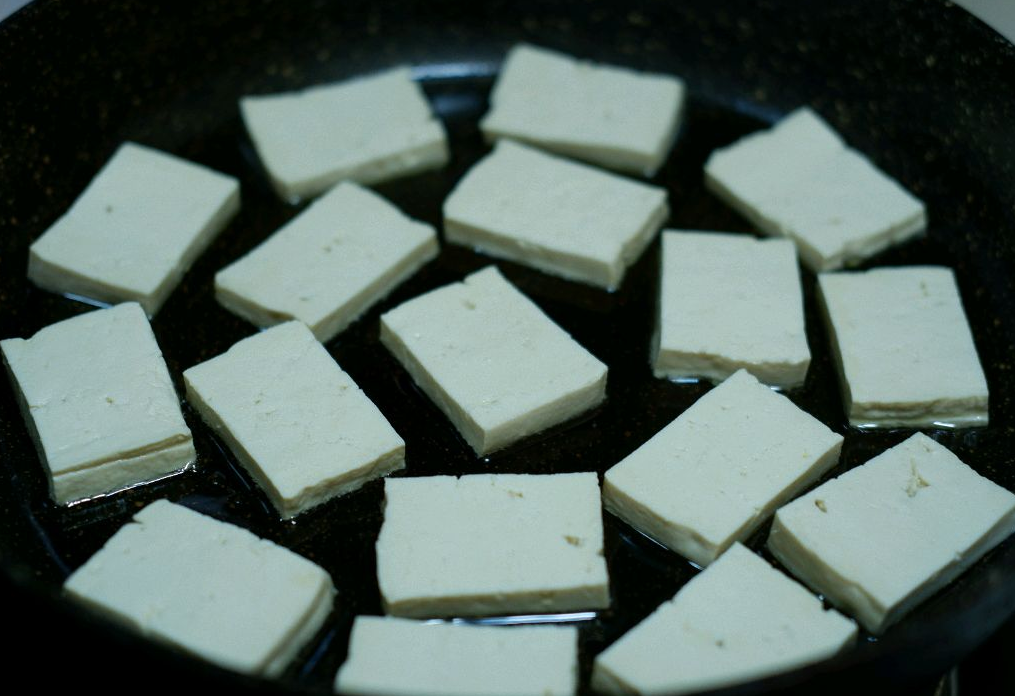 Fry diced tofu in hot oil in a non-stick pan slowly. Use a flat-bottomed pan for even frying.