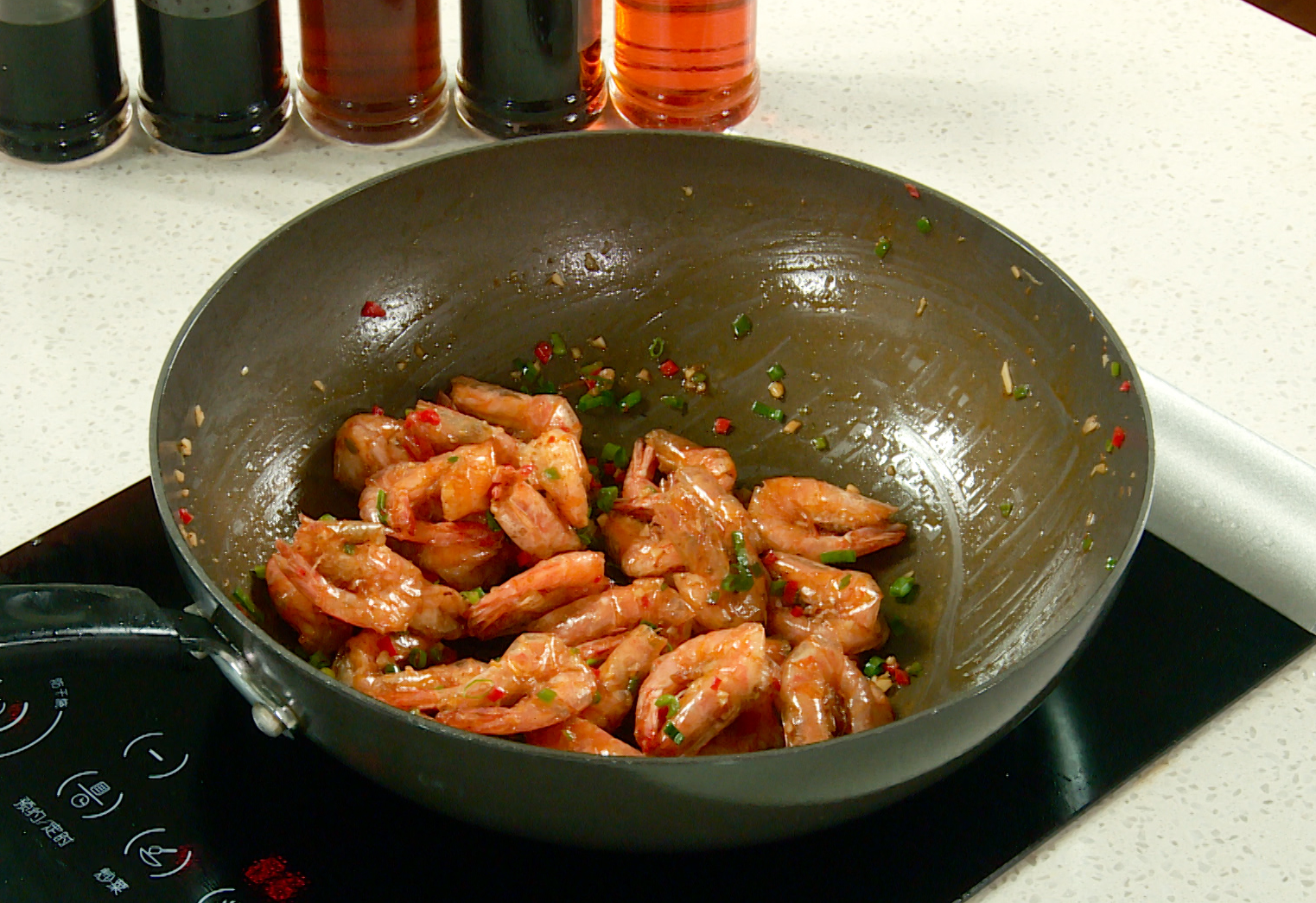 Fry shrimp, coat in sauce, add green onion, stir-fry for flavor.