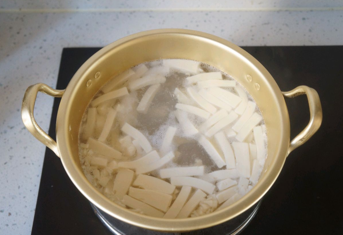 Boil thin slices of soft tofu in water to cook.