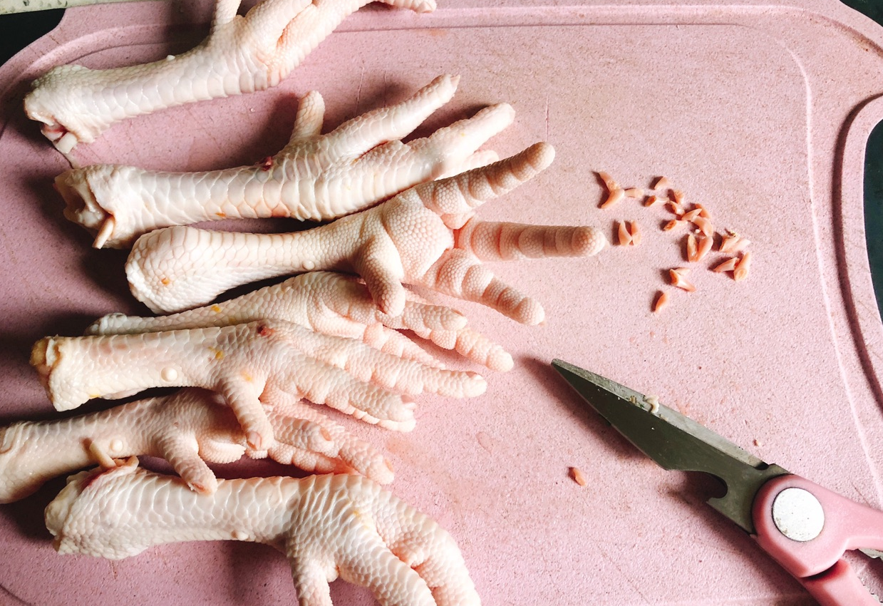 Clean 500g chicken feet, trim nails for quicker cooking and easier deboning.