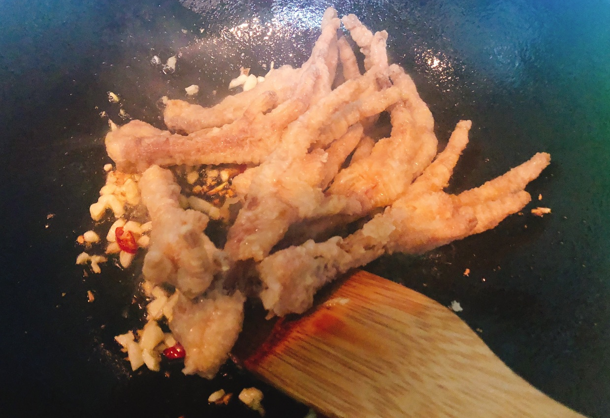 Add and stir-fry chicken feet in the pan.