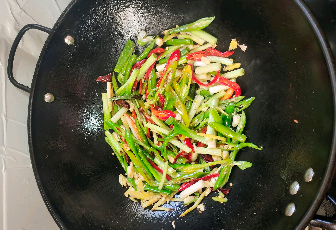 Stir-fry Erjingtiao chili peppers, celery, and green onion.