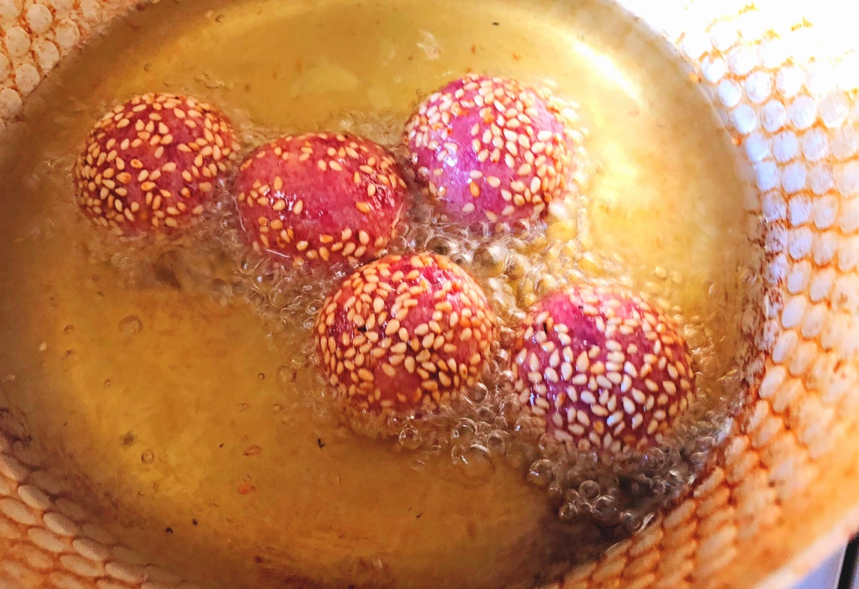 Fry sesame balls until golden brown, then remove from oil.