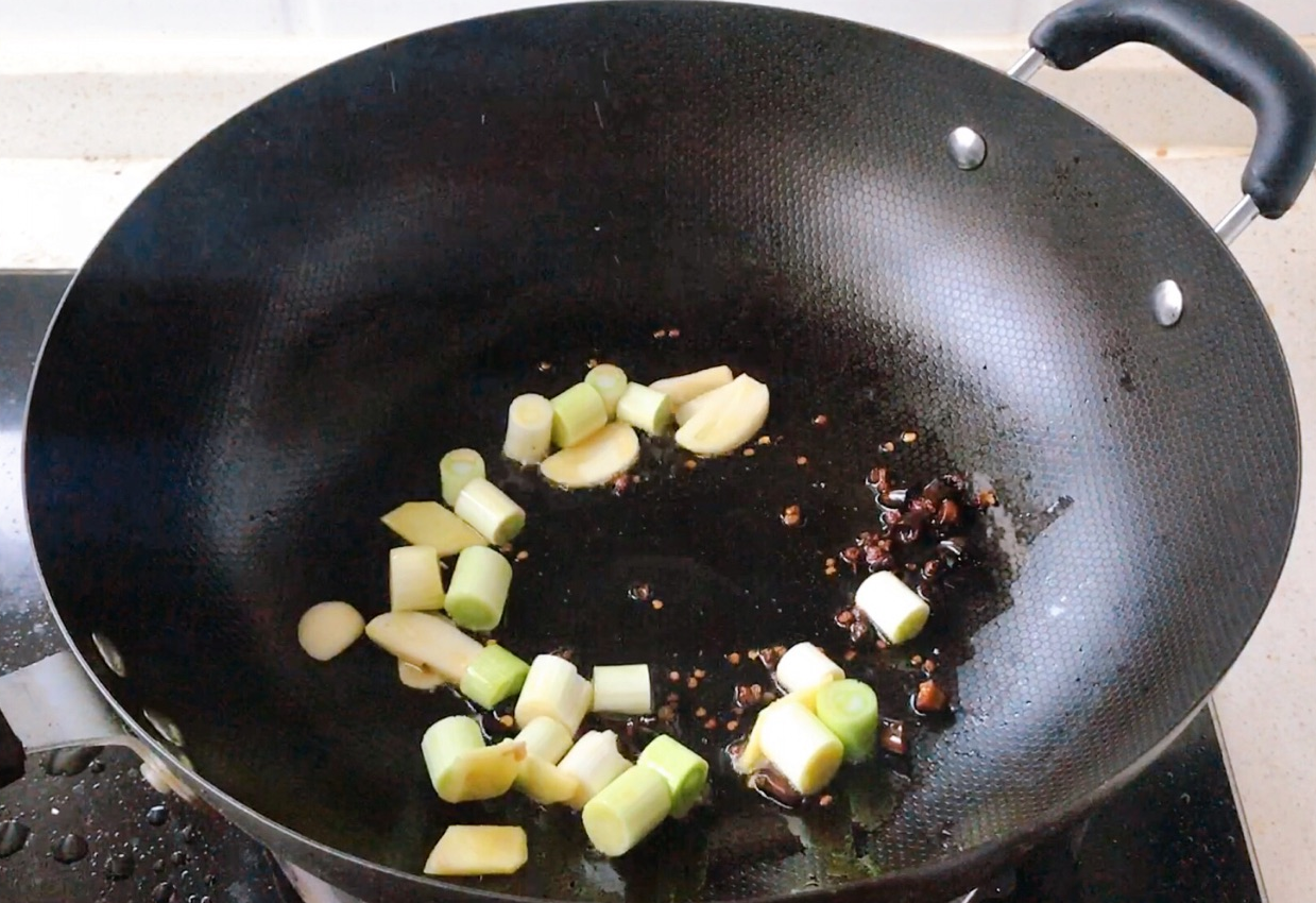 Stir-fry a spicy oil paste with scallions, ginger, and garlic until fragrant.