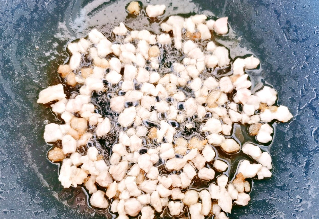 Cook diced pork belly in oil until browned.