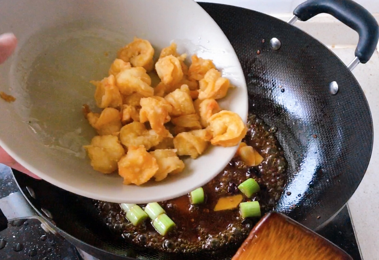 Stir-fry shrimp balls in thickened sauce for a delicious coating.