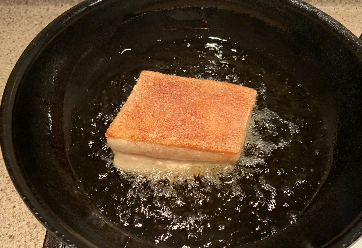 Fry pork until golden and bubbly, then flip.