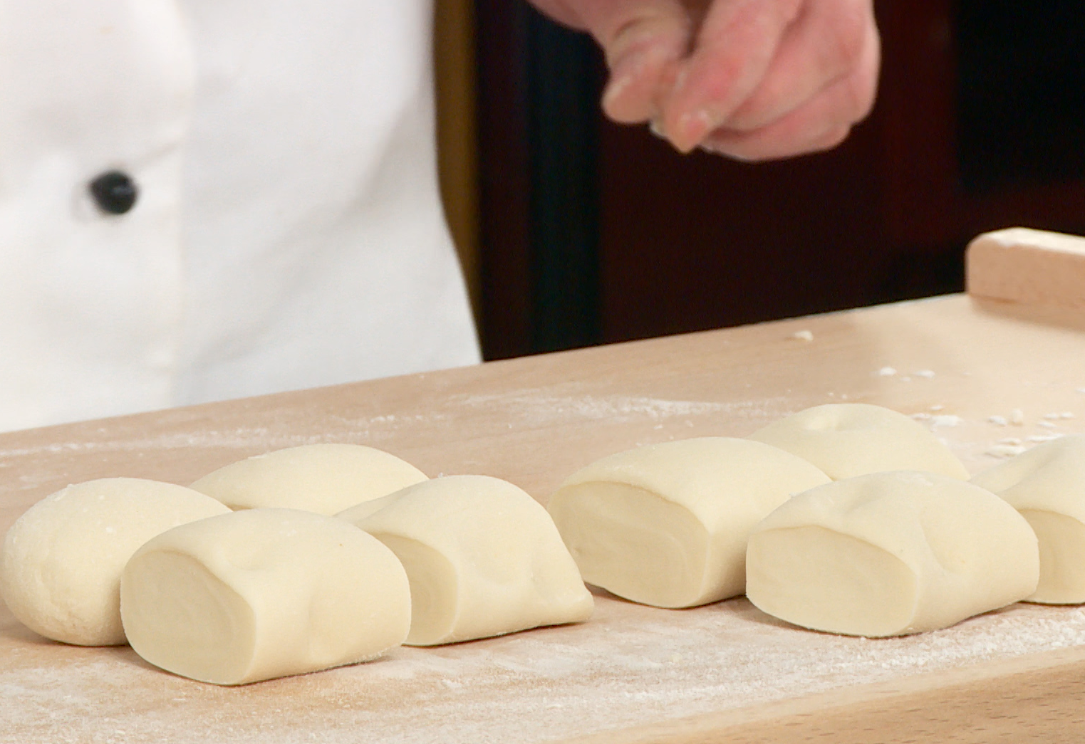 Knead dough with flour, shape into pieces, and flatten with rolling pin.