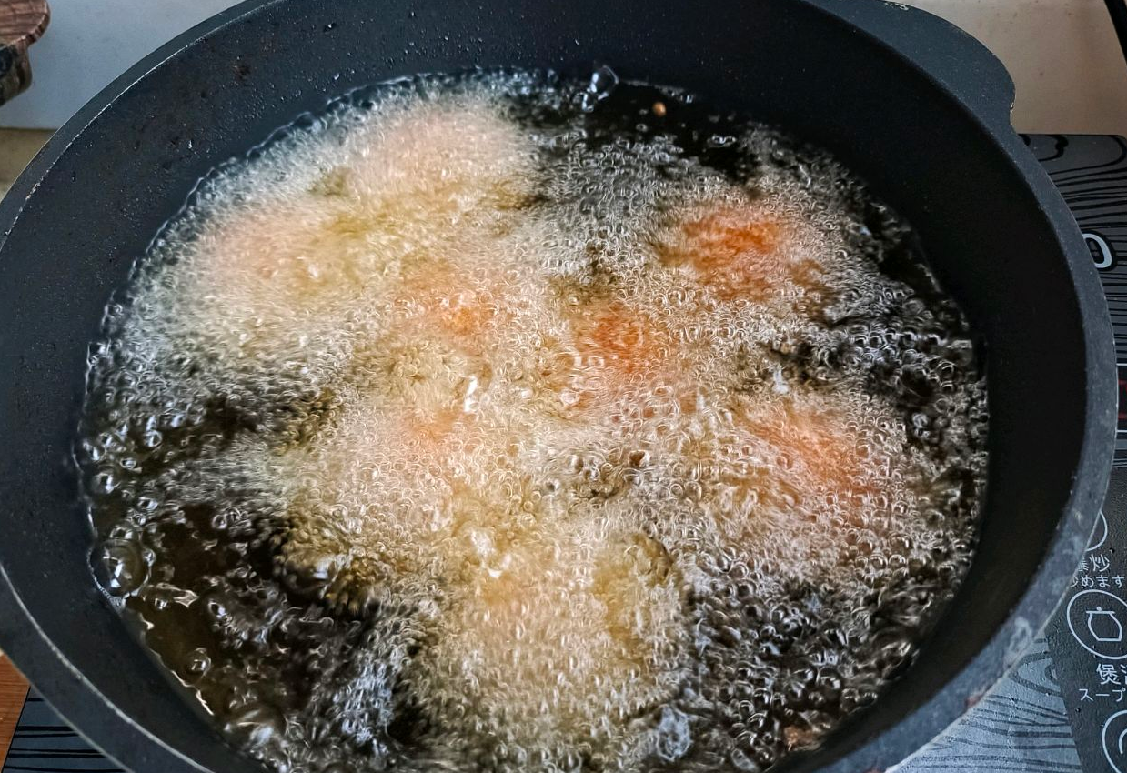 Fry meatballs in heated oil until golden brown and crispy.