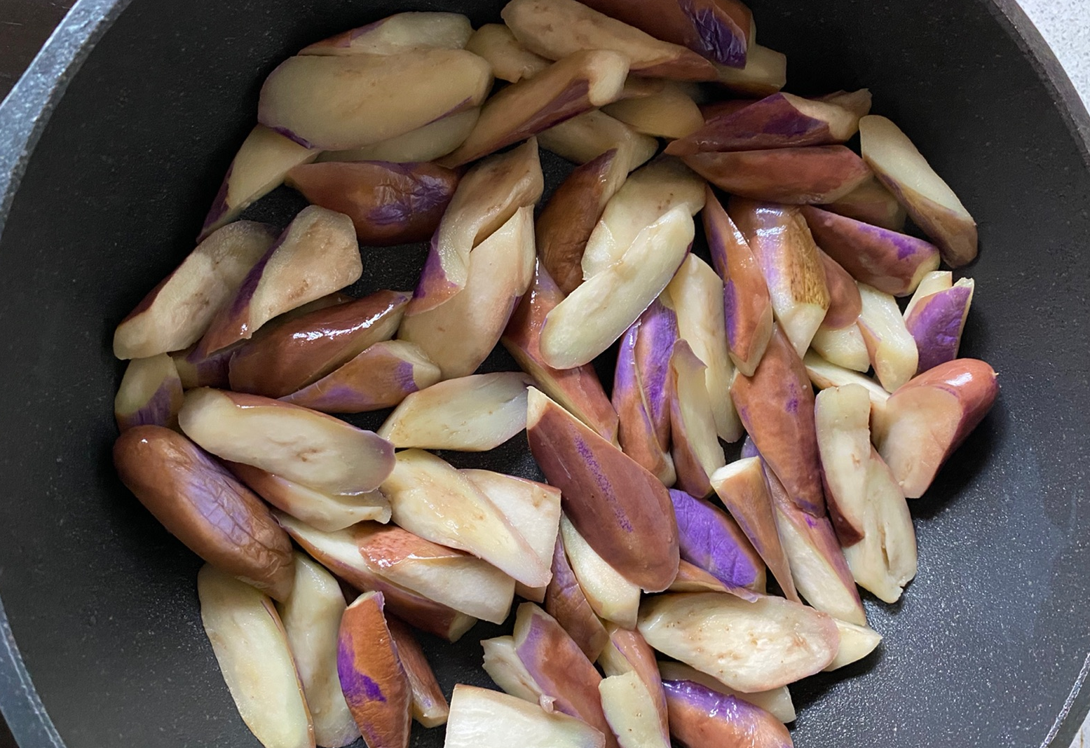 Stir-fry eggplant in oil until soft, then set aside.