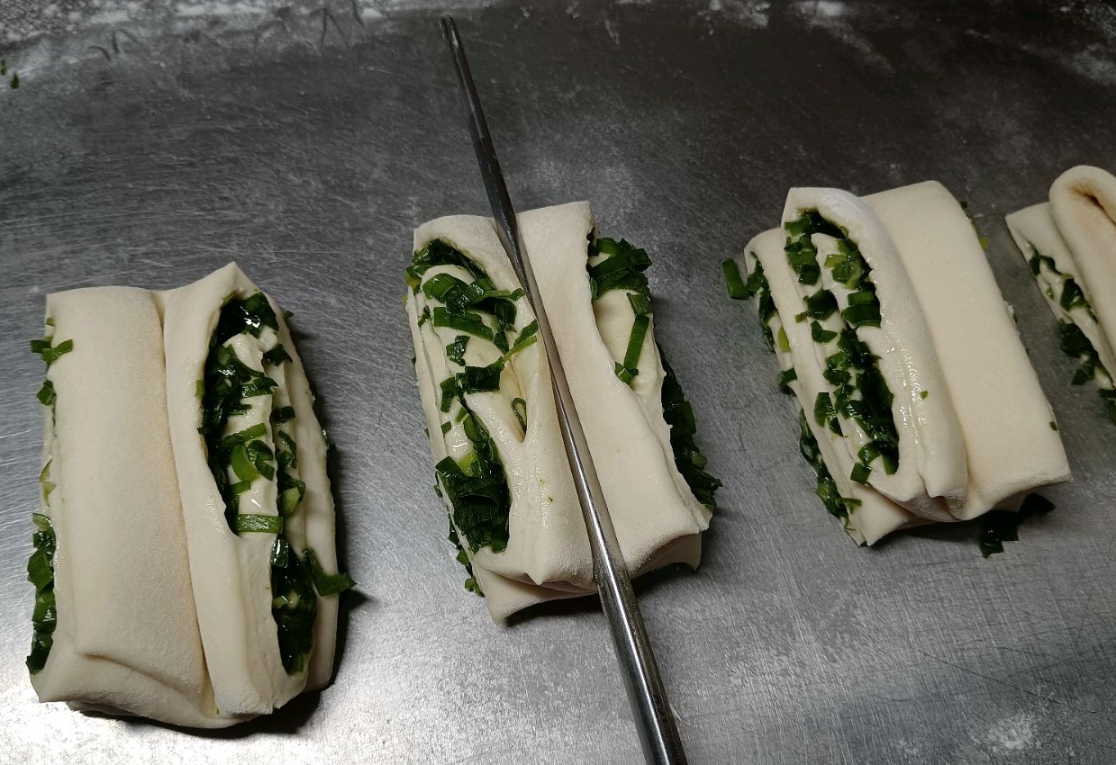 Instructions for stretching a piece of dough with chopsticks.