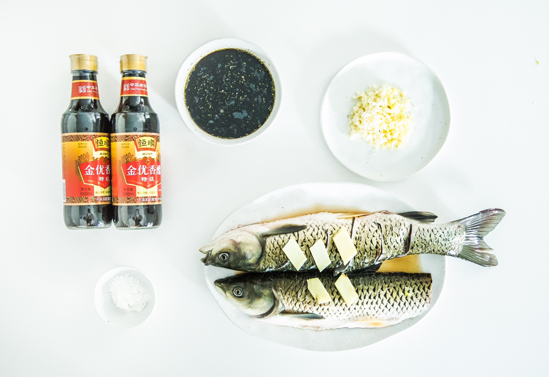 Marinate grass carp in ginger, garlic, cooking wine, and salt. Prepare vinegar sauce with vinegar, sugar, soy sauce, and cooking wine.