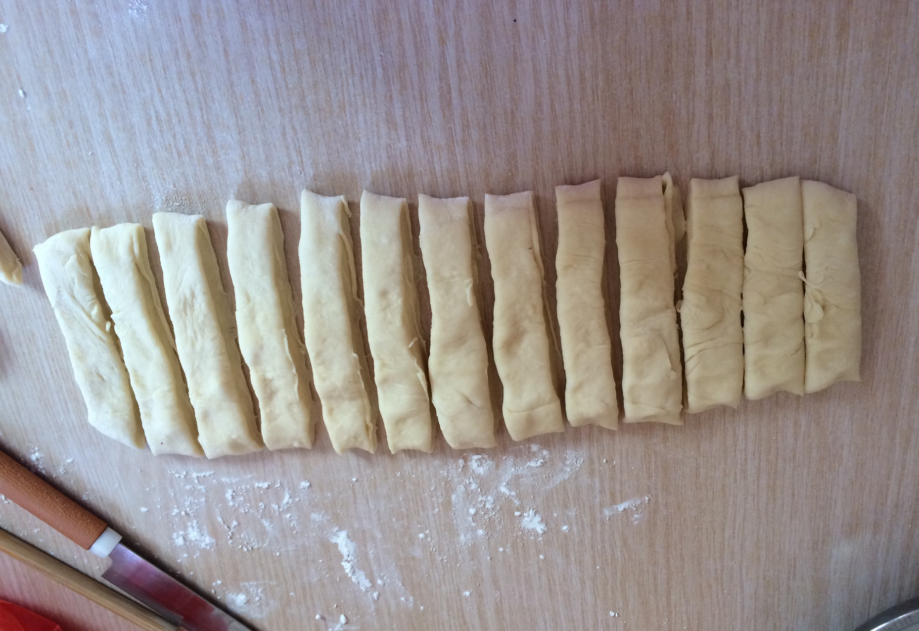 Knead dough, flatten into sheet, cut into strips with knife.