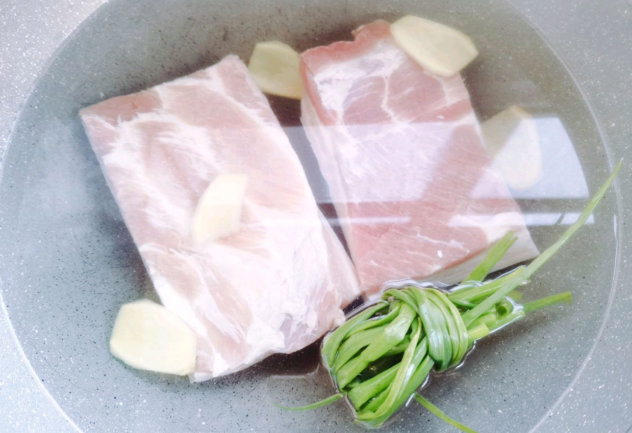 Blanch pork belly with scallions, ginger, cooking wine, and water to remove gamey odor.