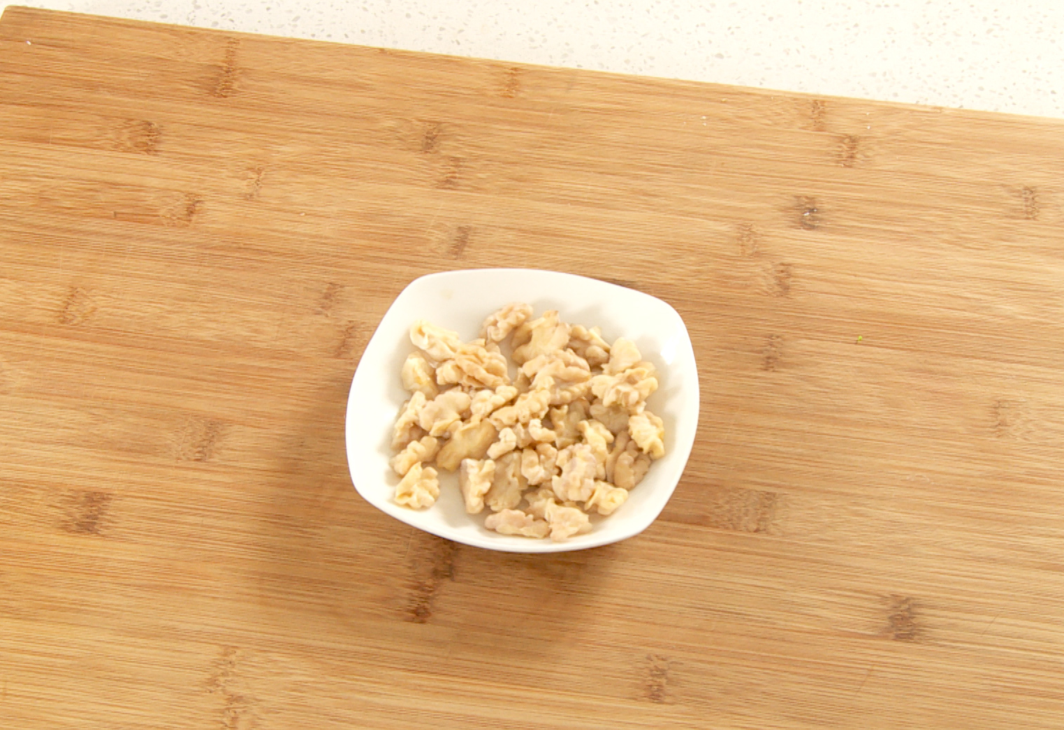 Prepare walnuts by soaking in boiling water for 10 minutes, then remove skins using a toothpick.