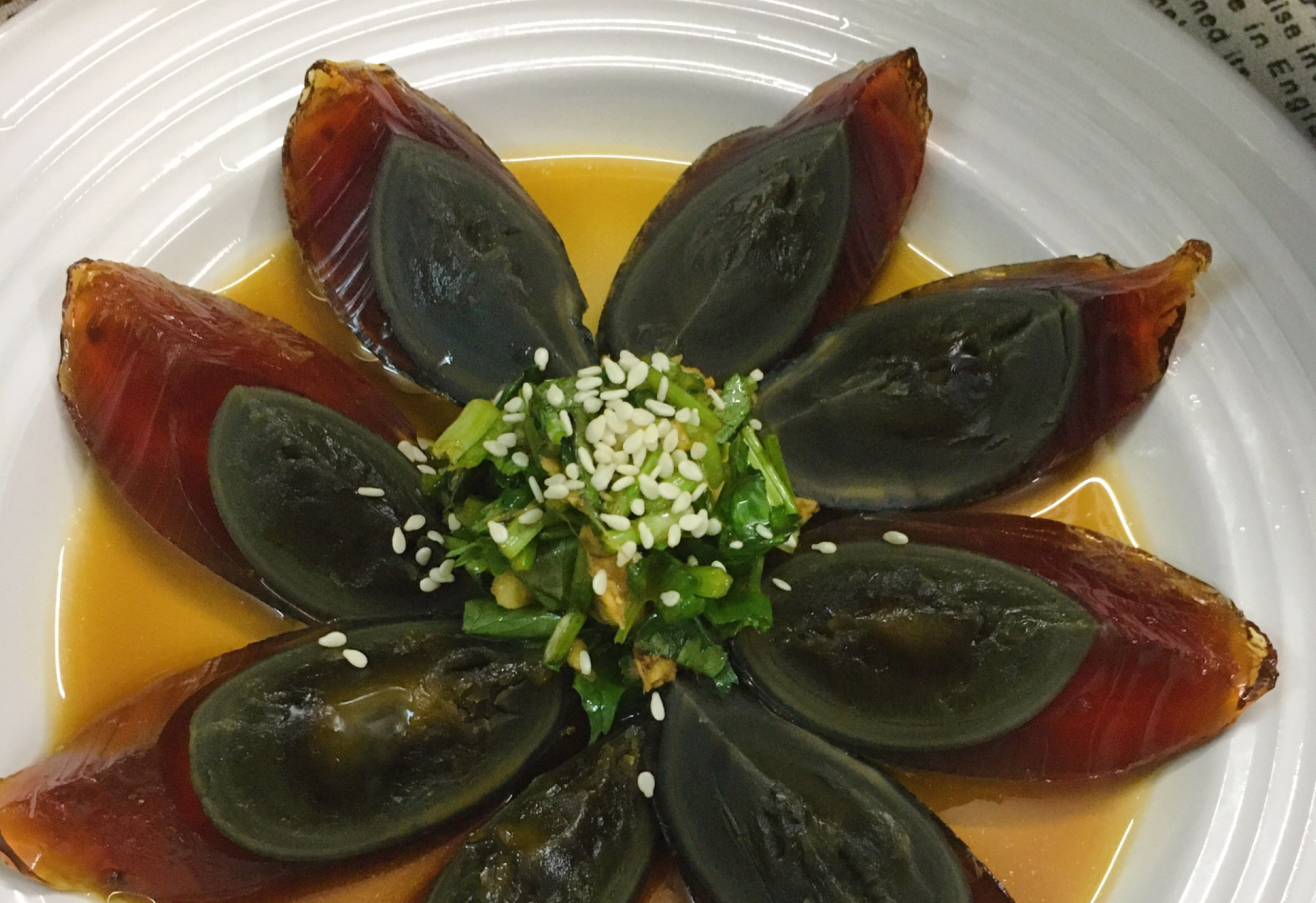 Drizzle dressing on century eggs for a tasty cold dish.