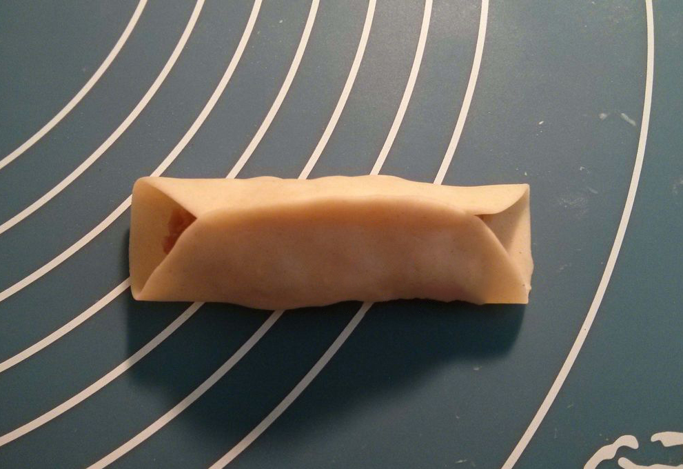 Folding wrapper edges together creates a secure seal for food.