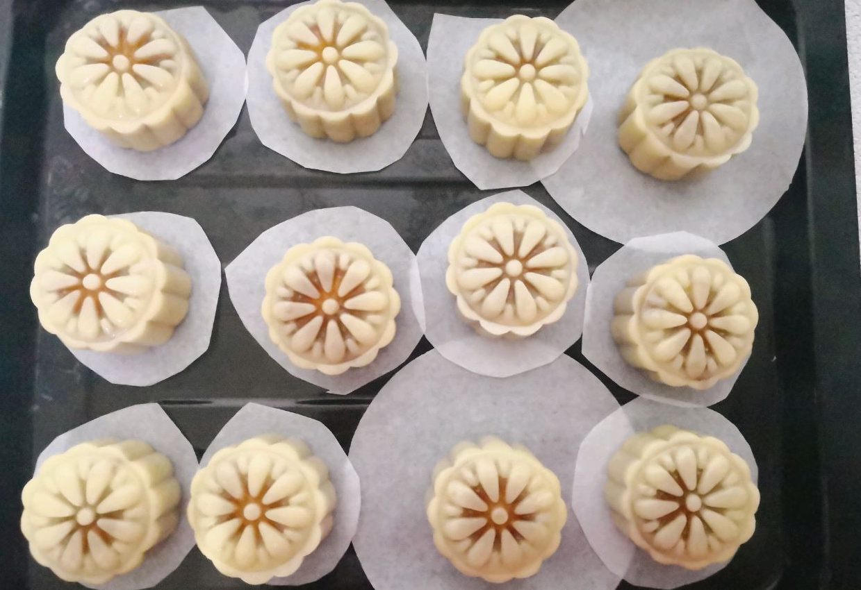 Remove mooncakes from mold, place on parchment paper on baking tray. Tip for non-stick trays.