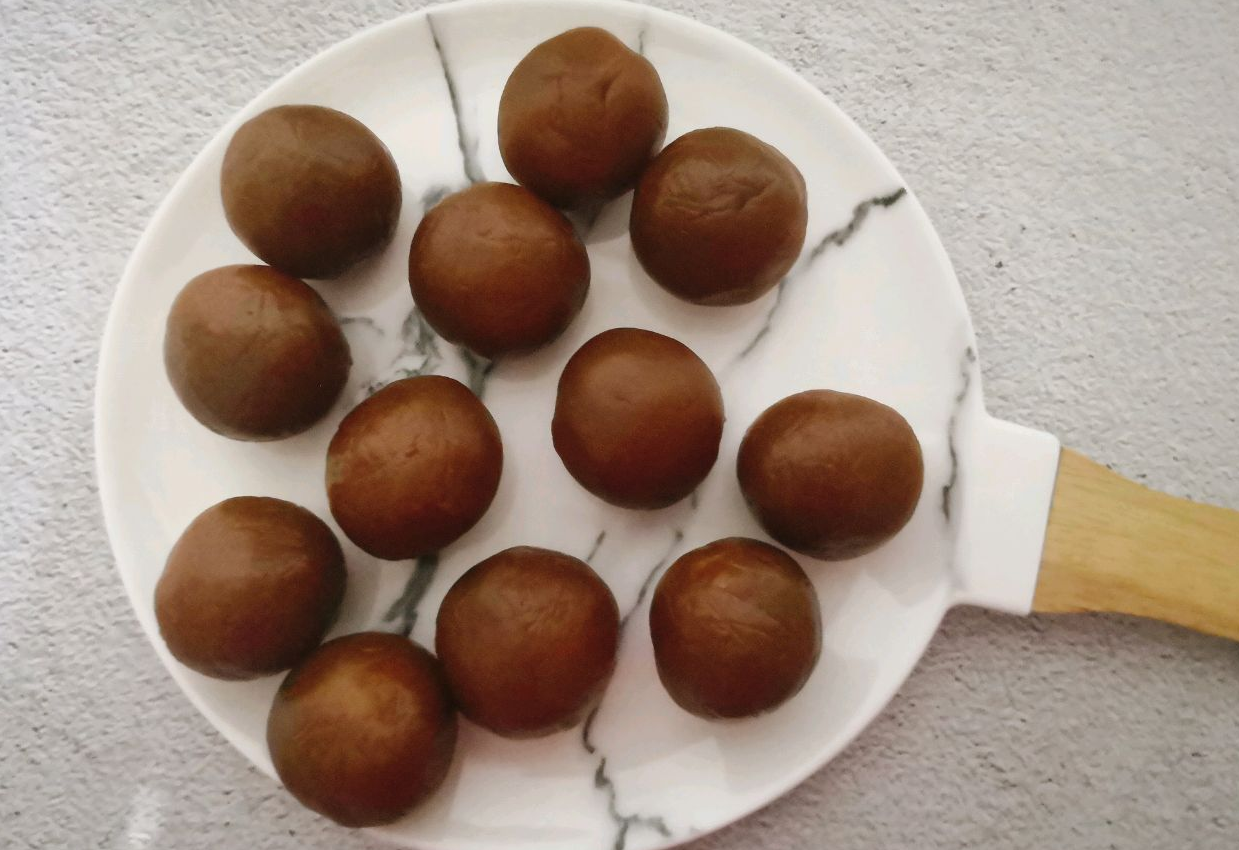 Shape lotus seed paste around salted egg yolk, roll into ball, and set aside.