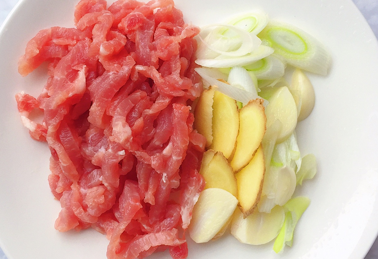 Prepare ingredients for stir-fry: Cut pork and spring onion into strips, chop ginger.