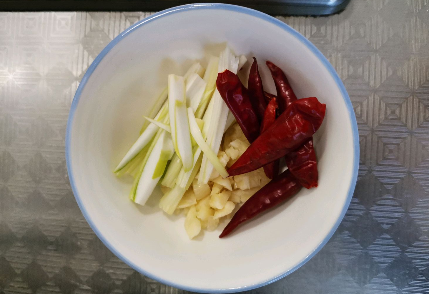 Crush garlic, cut scallions, and wash chili peppers for cooking.