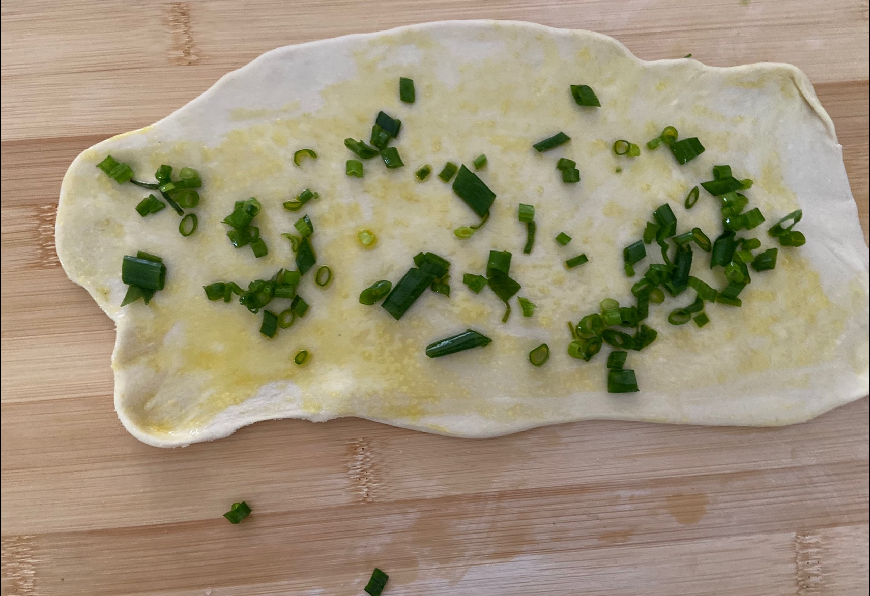 Sprinkle salt, brush oil, add scallions evenly on dough; top with more scallions.