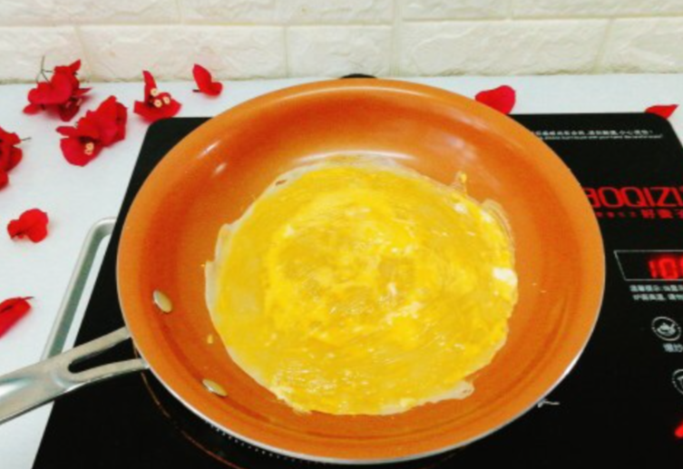 Spread cracked eggs evenly over pancake batter and spread with spatula.