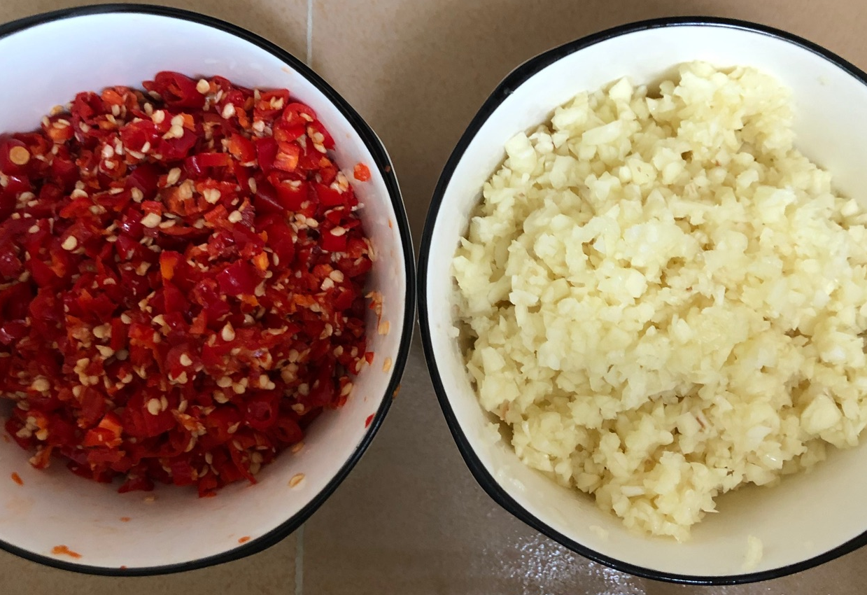 Prepare garlic and chilies: have chopped garlic and bird's eye chilies ready.