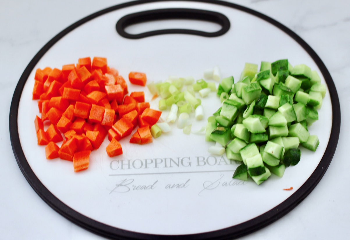 Prepare vegetables: Wash and chop green onion, cucumber, and carrot into small pieces.