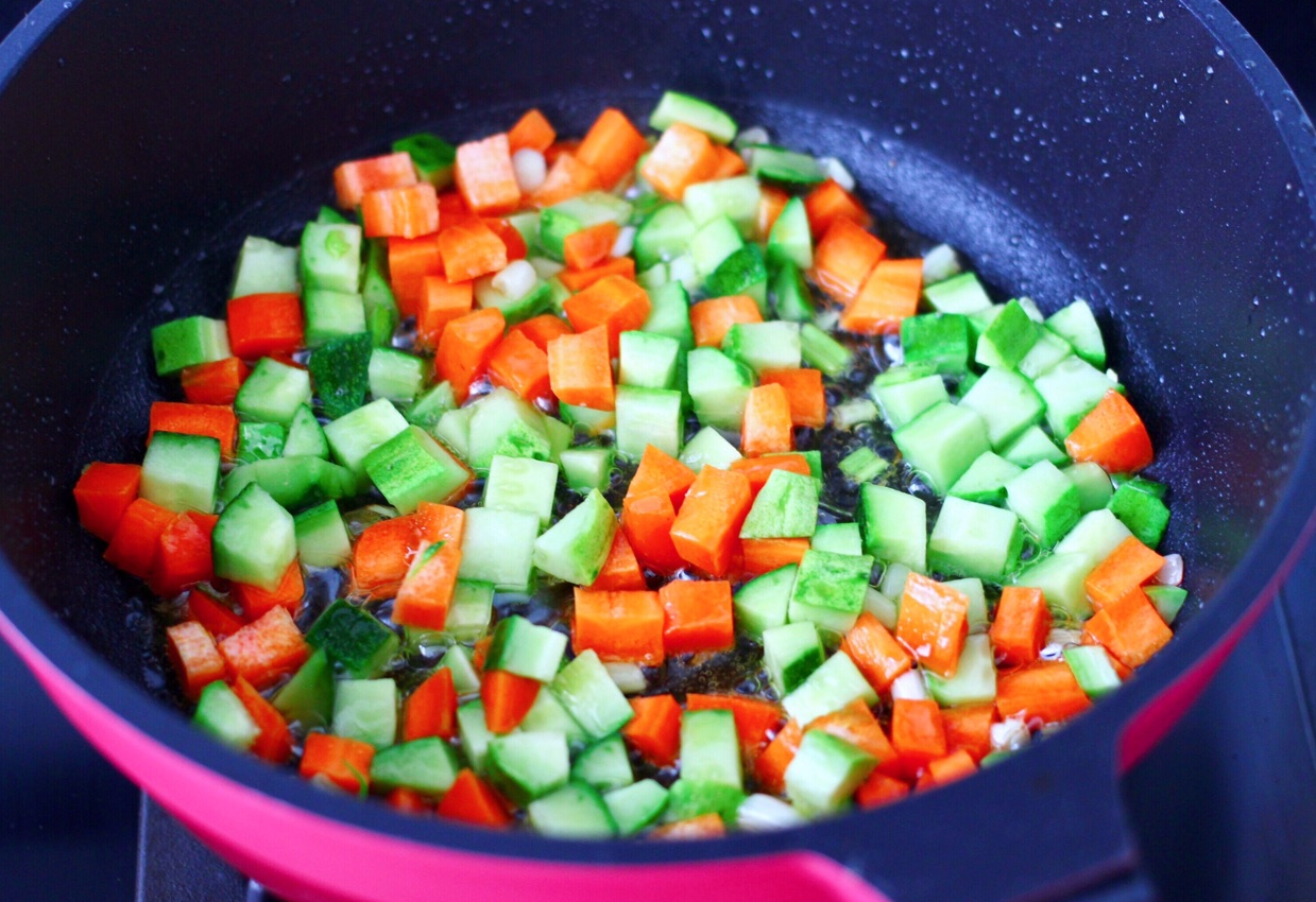 Sauté green onions, cucumber, and carrots in oil until cooked.