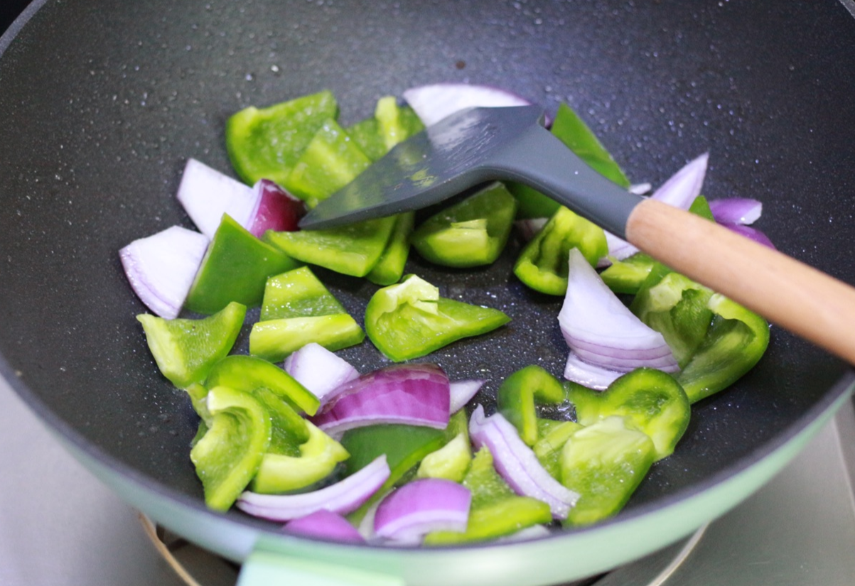 Stir-fry onion and green bell pepper in hot oil until fragrant and softened.