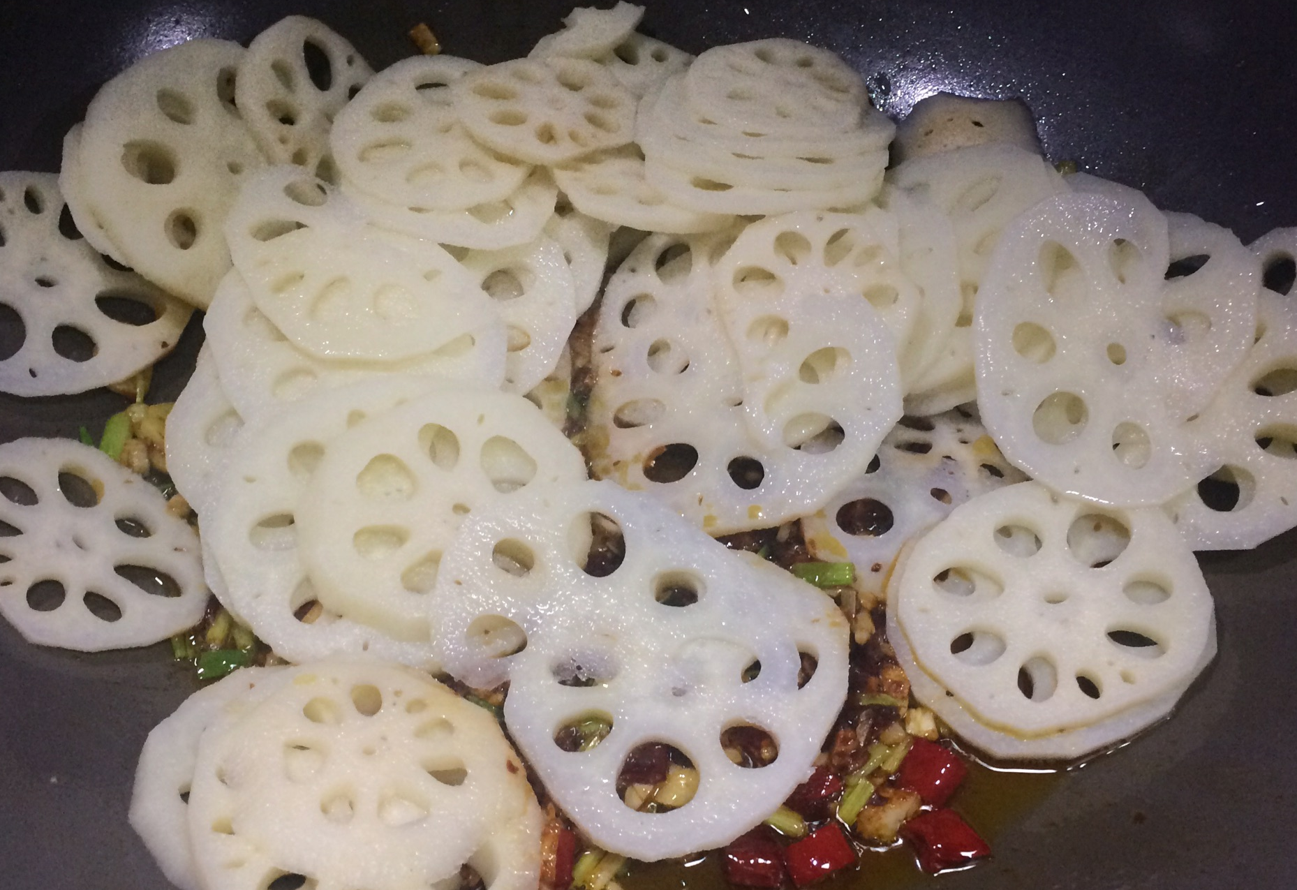 Stir-fry lotus root slices for desired texture: crispier with short time or softer with longer time.