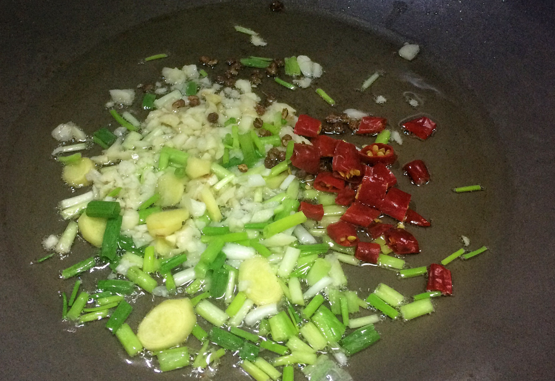 Sauté chili peppers, peppercorns, ginger, garlic & onion in hot oil for flavor.