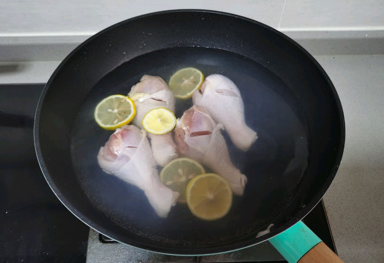 Instructions for preparing and blanching chicken thighs with lemon slices.