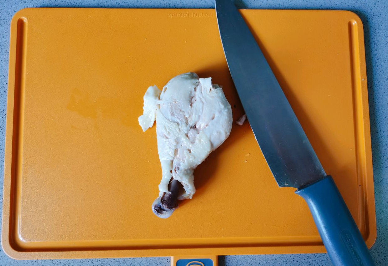 Cool and pound chicken thighs on a cutting board to separate meat from bones.