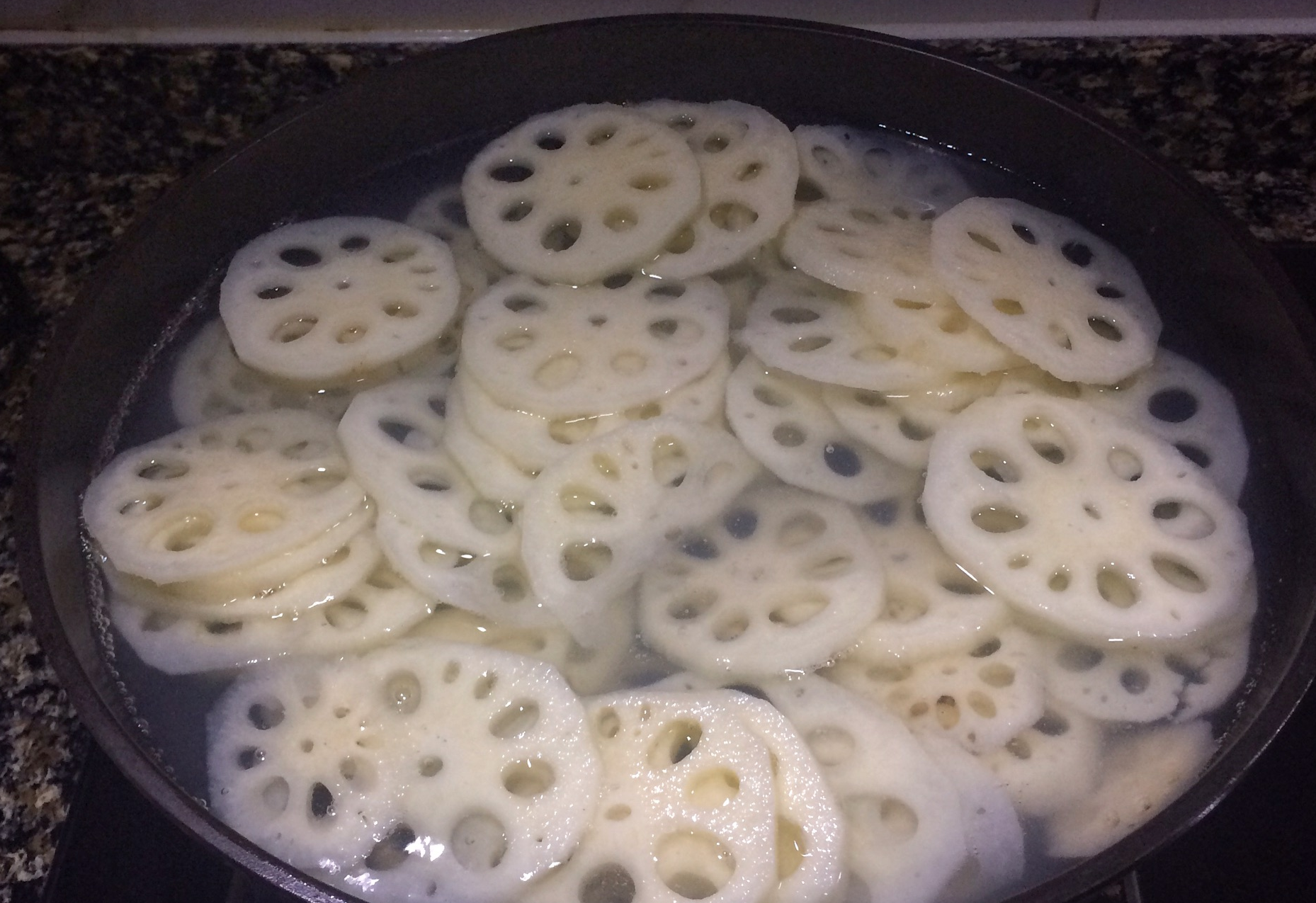 Blanch lotus root slices briefly in boiling water.