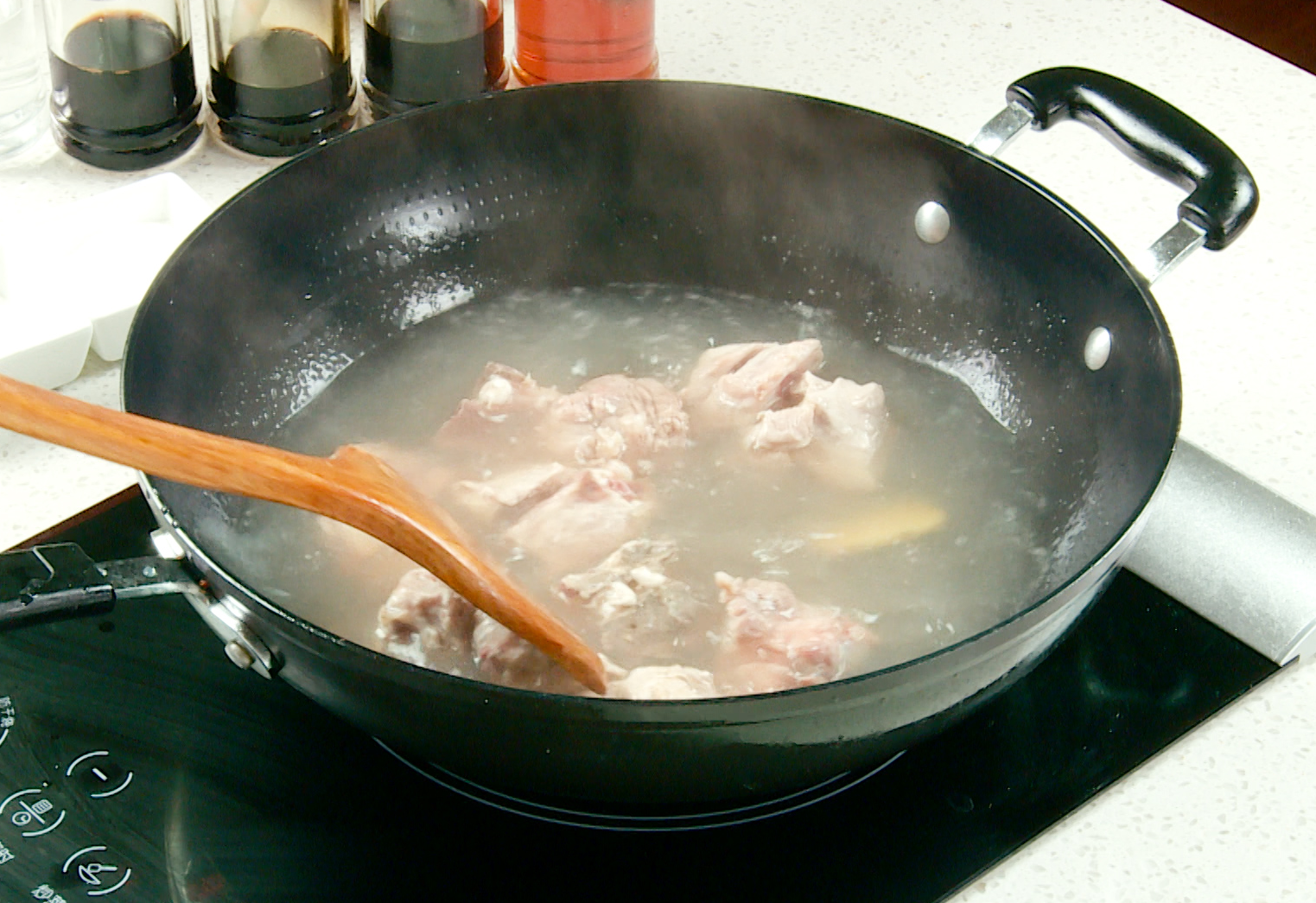 Blanch pork ribs by boiling with ginger and cooking wine, then rinse under cold water.