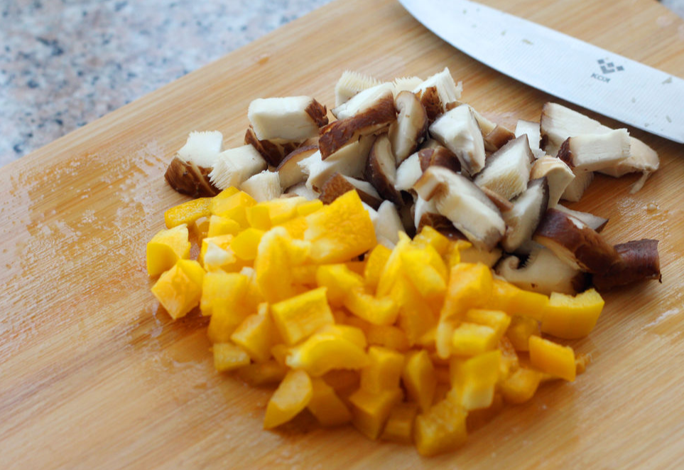 Dice bell peppers and shiitake mushrooms into small pieces.